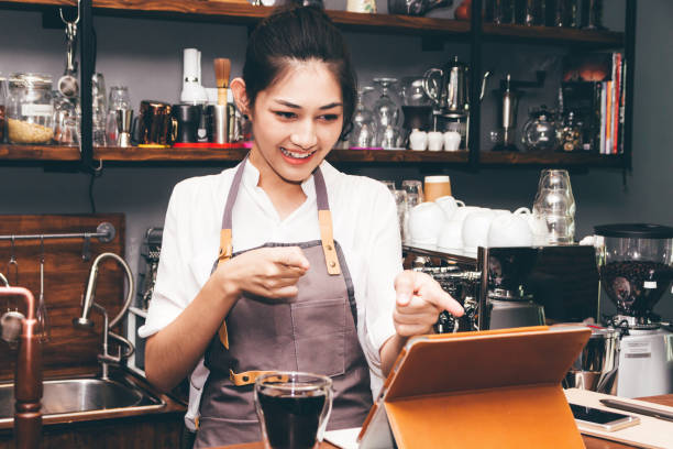istock Barista woman using digital tablet compute in coffee shop counter bar 921602206