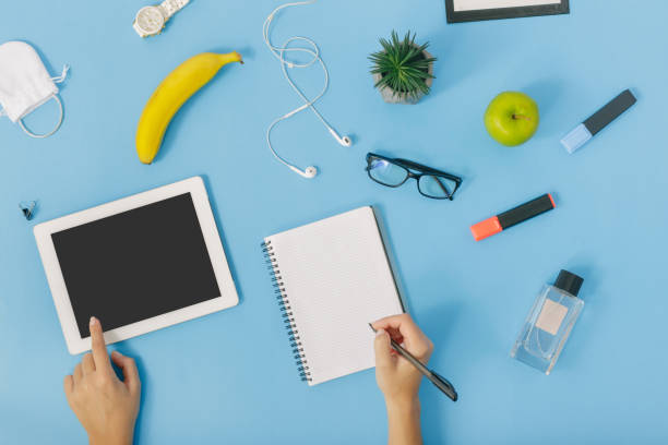 istock Flat lay, top view of woman at blue background with tablet and notebook 921602290