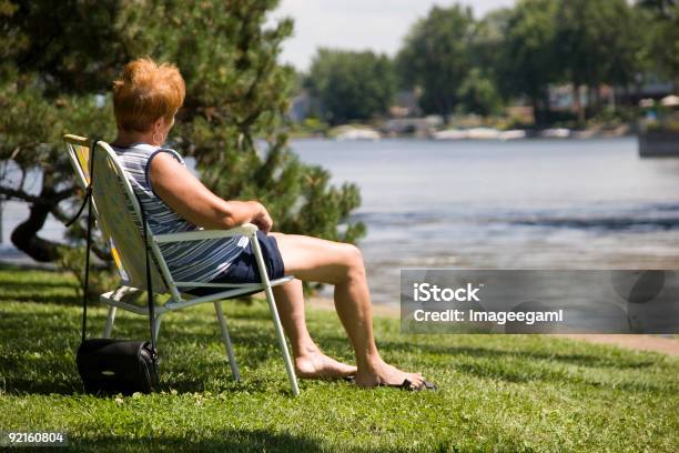 Mujer Sentada En Un Río Foto de stock y más banco de imágenes de Adulto - Adulto, Adulto maduro, Aire libre