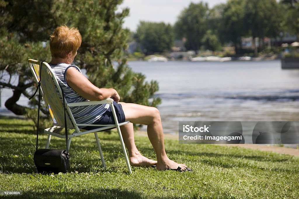 Donna seduta in un fiume - Foto stock royalty-free di Adulto