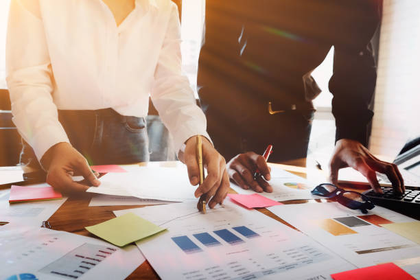 istock business meeting concept, calculate financial & budget & stock market data document with notebook and laptop computer in working on wood desk in office. 921610196