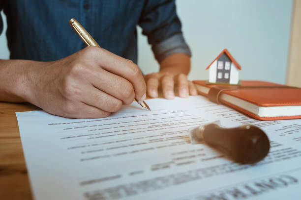 istock customer sign contract and pressing rubber stamp on house contract document. Agreement concept. 921612378