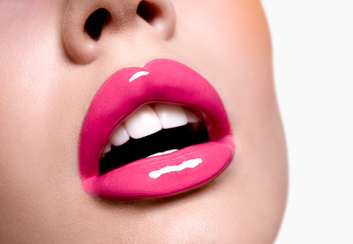 Beautiful pink glossy lips and perfect teeth.