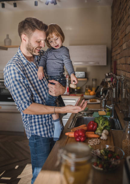 istock Happy father and son preparing healthy meal in the kitchen. 921617192