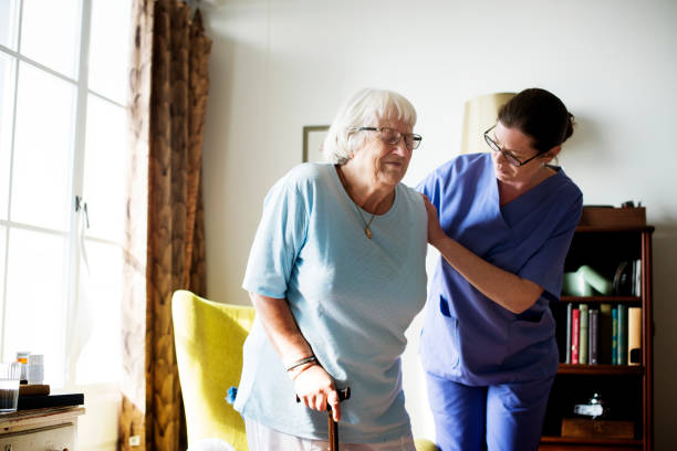 pielęgniarka pomaga starszej kobiecie stać - resting zdjęcia i obrazy z banku zdjęć