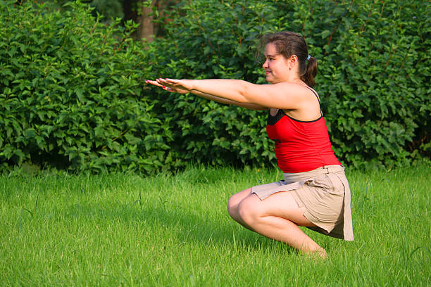 Girl doing curtsey on grass stock photo