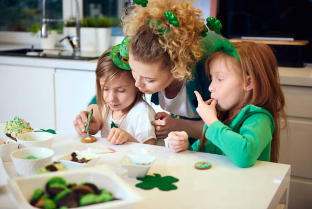 familia decorando galletas en la cocina - st patricks day irish culture child leprechaun fotografías e imágenes de stock