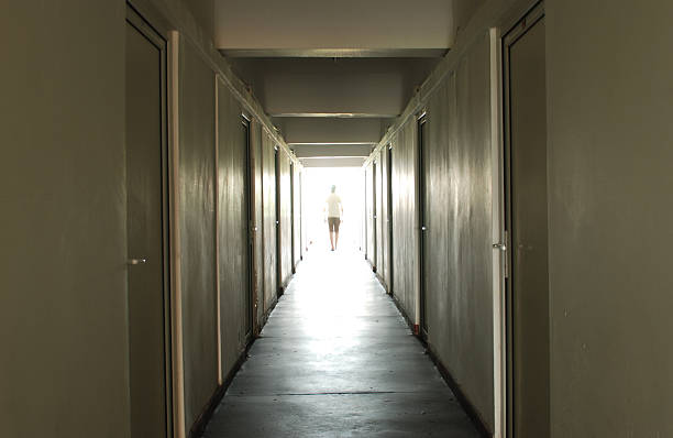 istock Man walking in a hallway towards a light 92162147