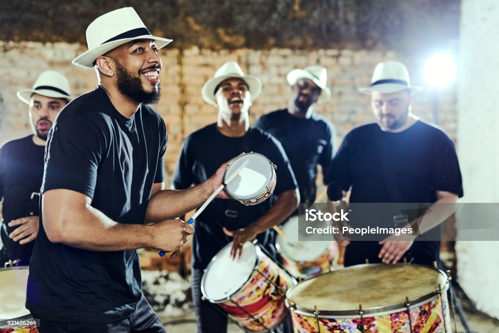 Feeling the rhythm in the drums Shot of a group of musical performers playing together indoors Performance Group Stock Photo