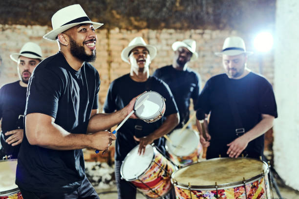 Feeling the rhythm in the drums Shot of a group of musical performers playing together indoors latin music photos stock pictures, royalty-free photos & images