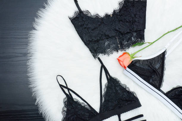 istock Fashion concept. Three lace bustier on a white fur. Top view 921627706