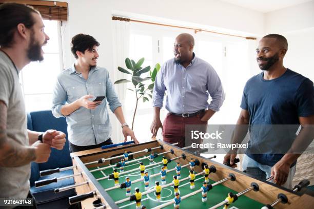 People Playing Table Football Stock Photo - Download Image Now - Games Room, Office, Friendship