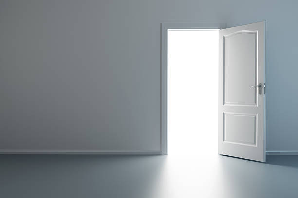 istock An empty room with a white door opening to a bright light 92165169