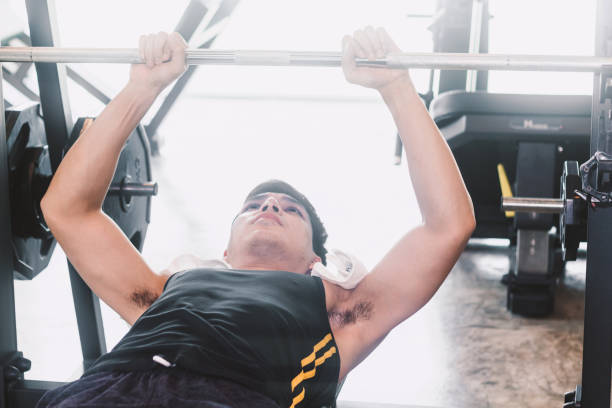 istock Fitness man doing weights exercises with dumbbell sitting at the gym 921659816