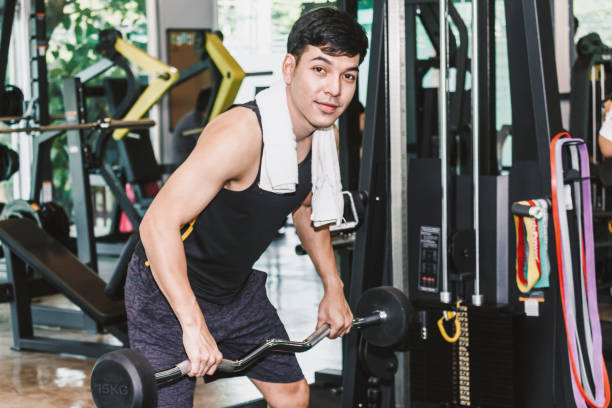 istock Fitness man doing weights exercises with dumbbell sitting at the gym 921659842