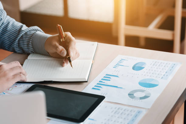 istock Businessman hand writing making note at office room and using tablet calculate finance. 921660058