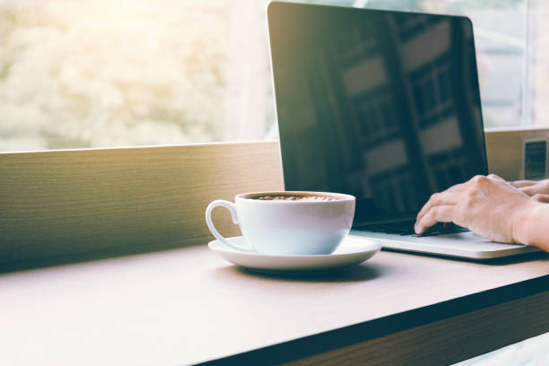 istock Human hand working on keyboard laptop with coffee in morning. 921660074