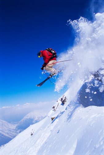 Fast girl snowboarder jumps from springboard high in mountains. Winter sports concept
