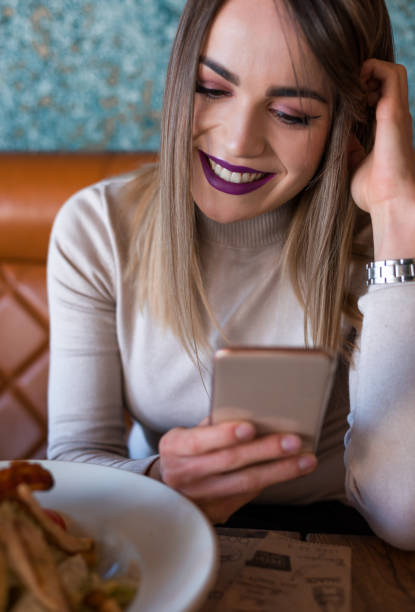 istock Beautiful woman with smart phone in cafe 921664168