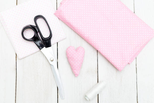 istock Pink heart stitched with his hands on a white wooden background. Handmade 921664590
