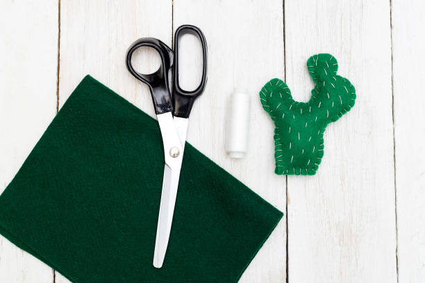 Green cactus from felt on a wooden background. Handmade flat lay