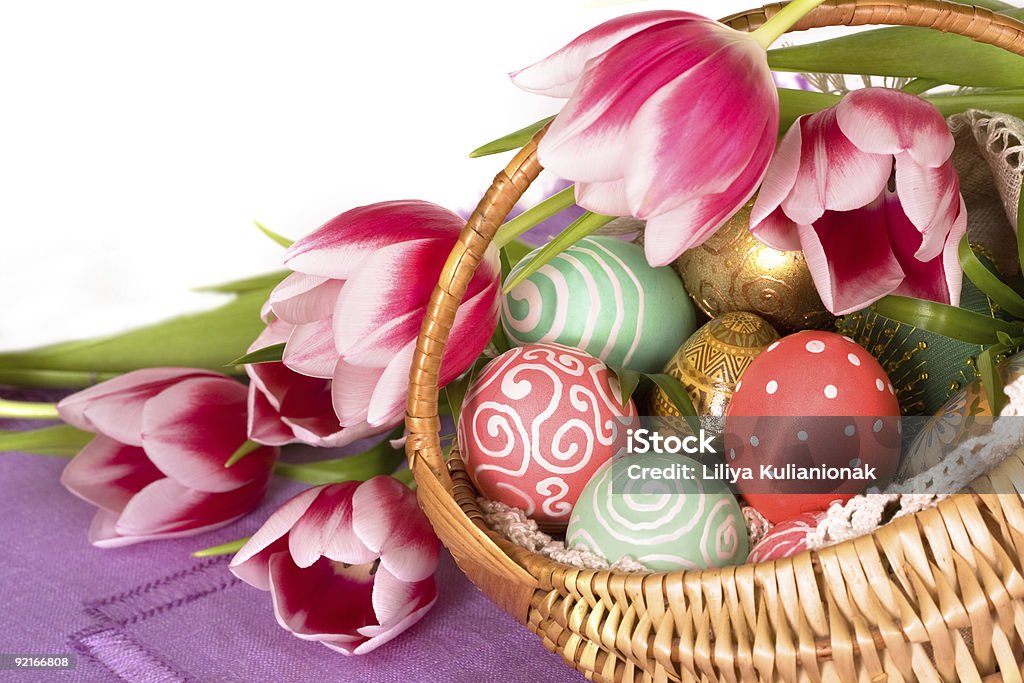 Easter Eggs and tilips pink Colorful Easter Eggs on the basket and tilips pink Basket Stock Photo