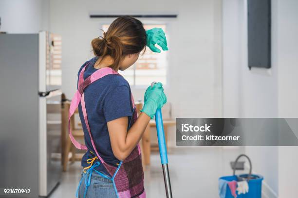 Foto de Jovem Cansada De Pé Na Sala De Estar e mais fotos de stock de Cansado - Cansado, Limpar - Atividade Móvel, Trabalho Doméstico