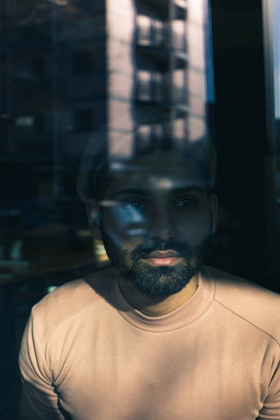 istock Indian man posing behind a reflecting glass 921674258