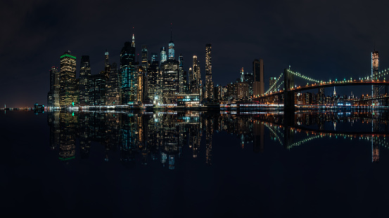 New York City skyline at night with reflection over the water