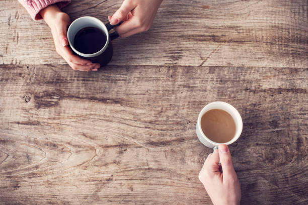 istock Holding coffee cup on wooden table 921677566