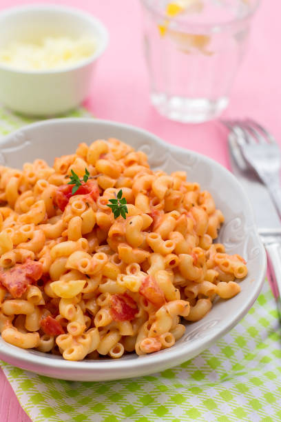istock Pasta macaronis coquillettes with tomato and processed cheese sauce 921681748