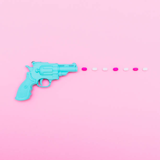 istock gun shoots a pink and white bullets 921681862