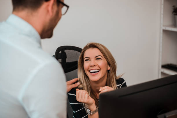 istock Cheerful young woman in office talking with man. 921690268