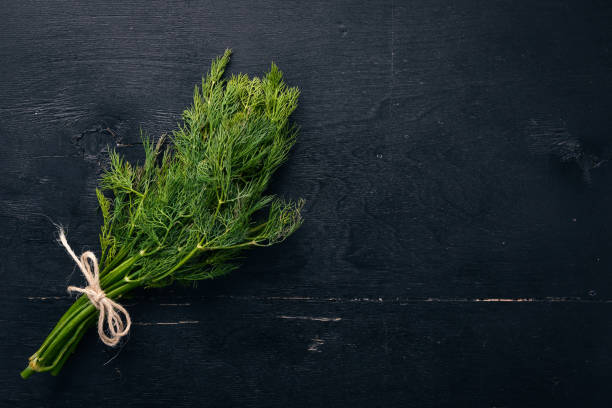istock Fresh green dill on a wooden background. Top view. Free space for your text. 921691066