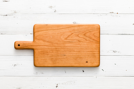Handmade cherry wood chopping board on white board, handmade wood cutting board