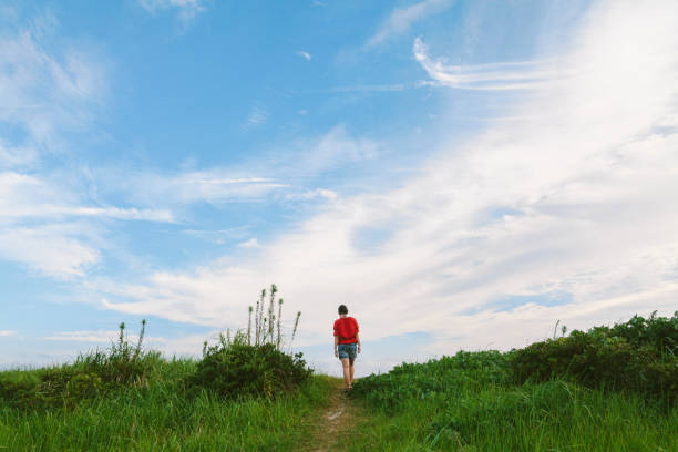 A young Japanese woman is walking by herself in nature in summer.