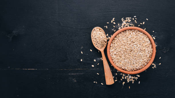 istock Oatmeal flakes in a plate on a wooden background. Top view. Copy space. 921696822