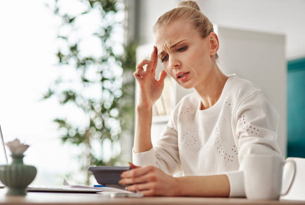 istock Worried woman with calculator at home office 921702900