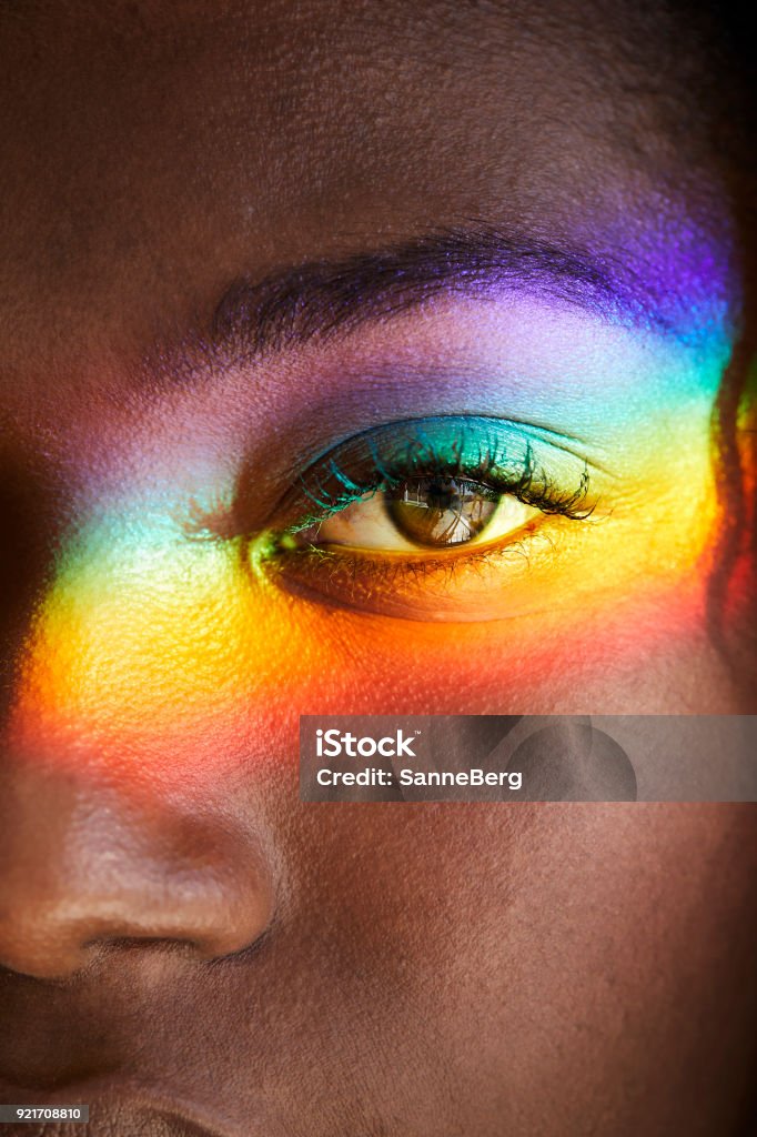 Rainbow light over eye Rainbow light over eye of beautiful woman, close up Rainbow Stock Photo