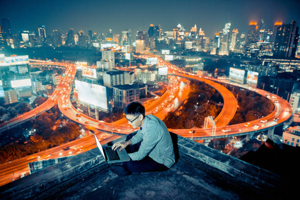 istock Asian businessman using phone and laptop with city  background, technology communication concept 921713012