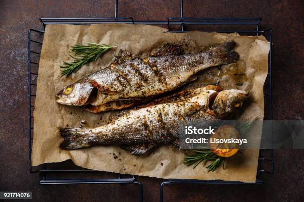Grilled Fish Sea Bass On Grill With Lemon And Rosemary Stock Photo - Download Image Now