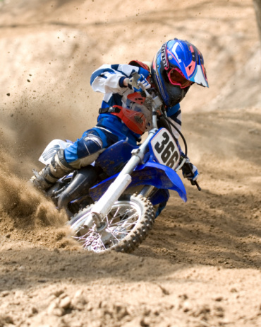Live shot of junior sportsman, motorcyclist training on motorbike at hot summer day, outdoors. Motocross sport, competition, male hobby, energy and ad