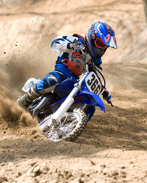 A photograph of a Pixstarr Motocross rider Corner shot of a rider in soft dirt. motorcycle racing stock pictures, royalty-free photos & images