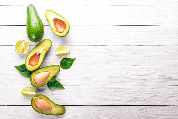 istock Avocado and lime on a wooden background. Top view. Free space for your text. 921715546
