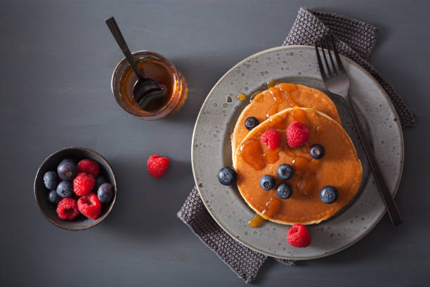 pancakes with blueberry raspberry honey and jam for breakfast - norway maple imagens e fotografias de stock
