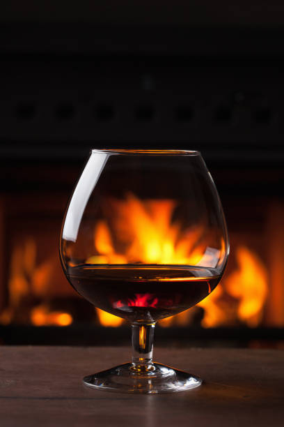 istock a glass of cognac in front of fireplace 921722250