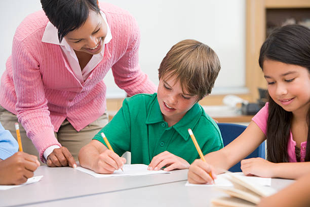 istock School teacher helping her pupils in class 92172562