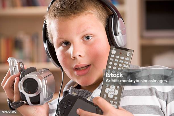 Młody Chłopiec Trzymając Wiele Urządzeń Elektronicznych - zdjęcia stockowe i więcej obrazów Brand Name Video Game