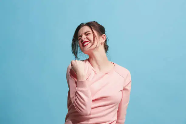 I won. Winning success happy woman celebrating being a winner. Dynamic image of caucasian female model on blue studio background. Victory, delight concept. Human facial emotions concept. Trendy colors