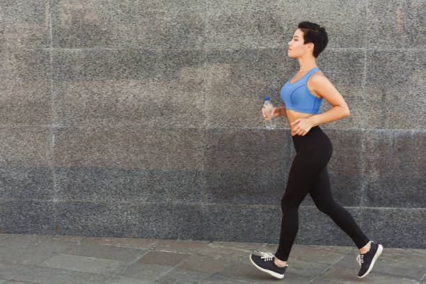 istock Young woman running in city copy space 921731606